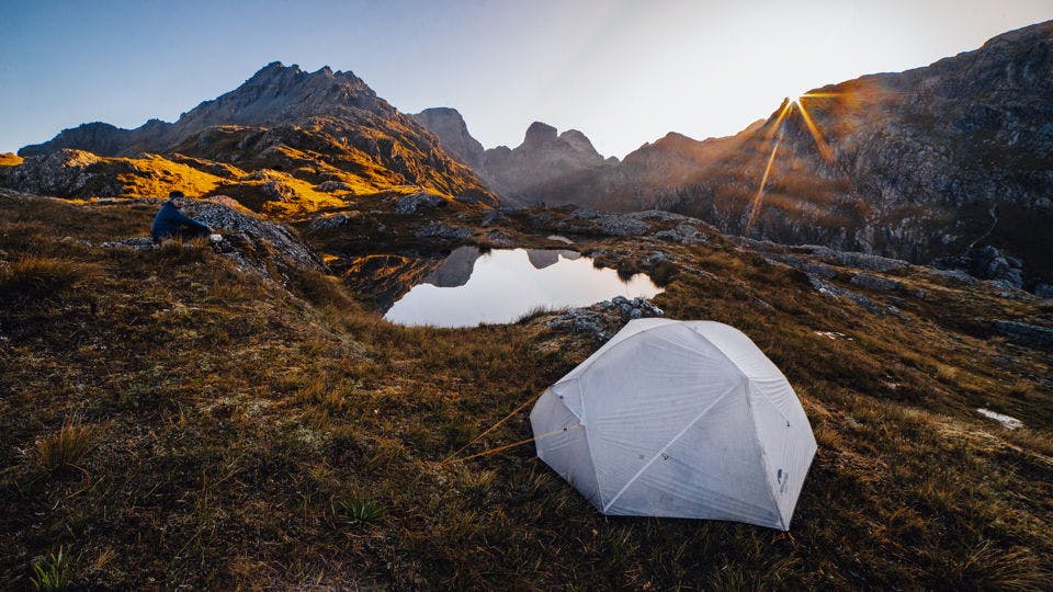 Tent and pound between mountains